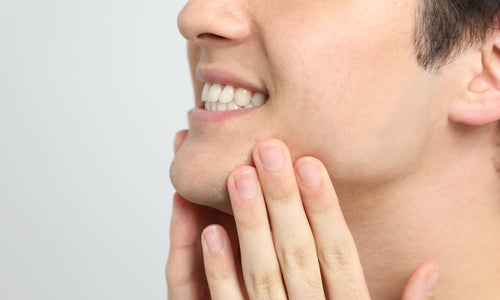 closeup of man rubbing chin