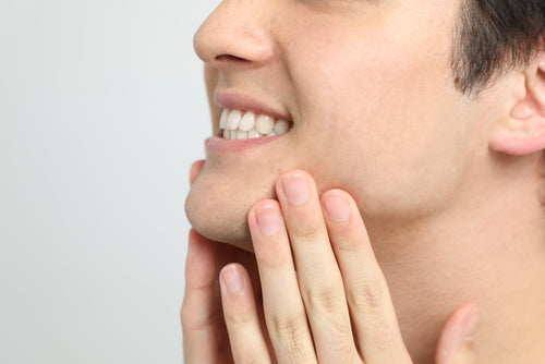 closeup of man rubbing chin