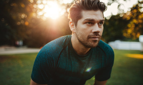 closeup of man standing hunched in park