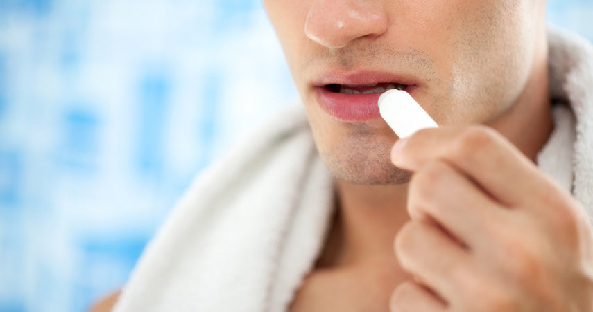 man applying balm to lips