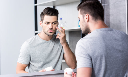 man applying facial cream