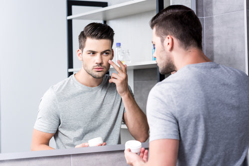 man applying facial cream