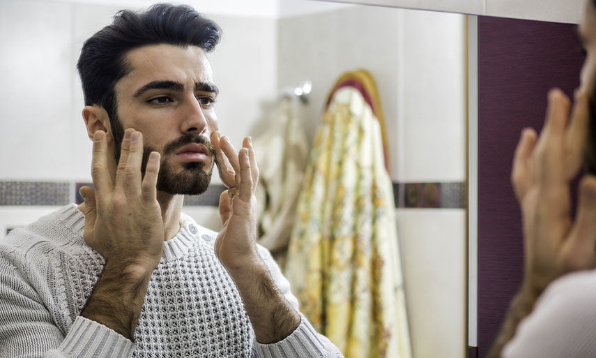 man applying facial moisturizer