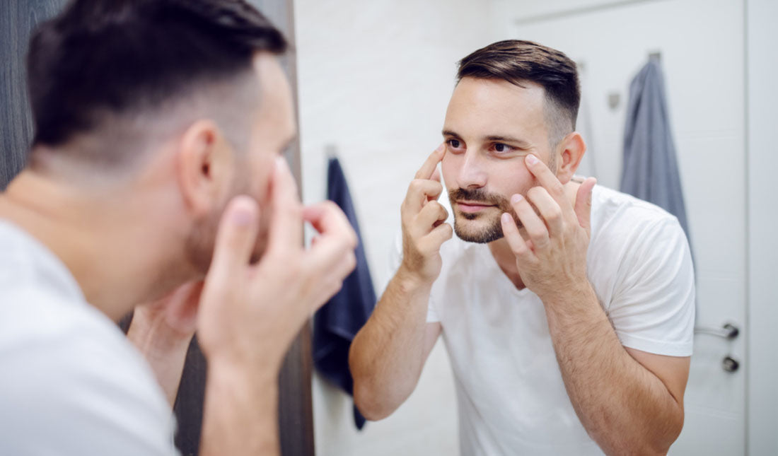 man checking for wrinkles under eyes