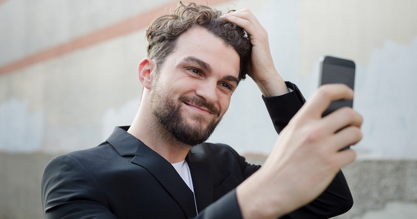 man fixing hair for selfie