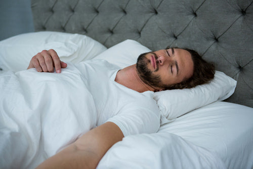 man sleeping on his bed