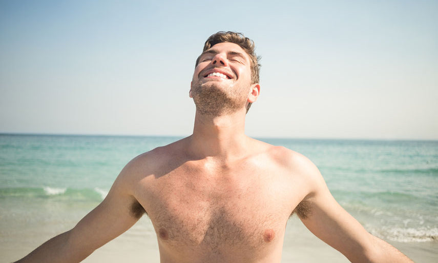 man smiling at camera on beach