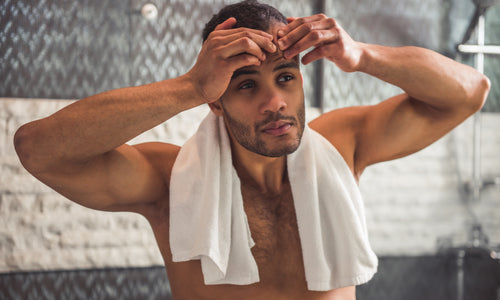 man popping pimple in bathroom