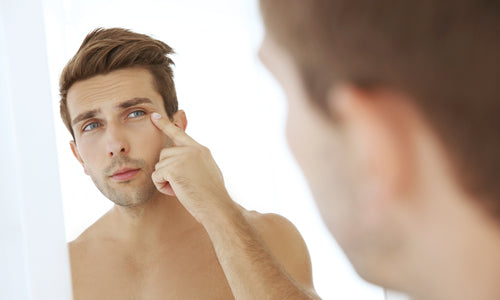 man checking face in mirror