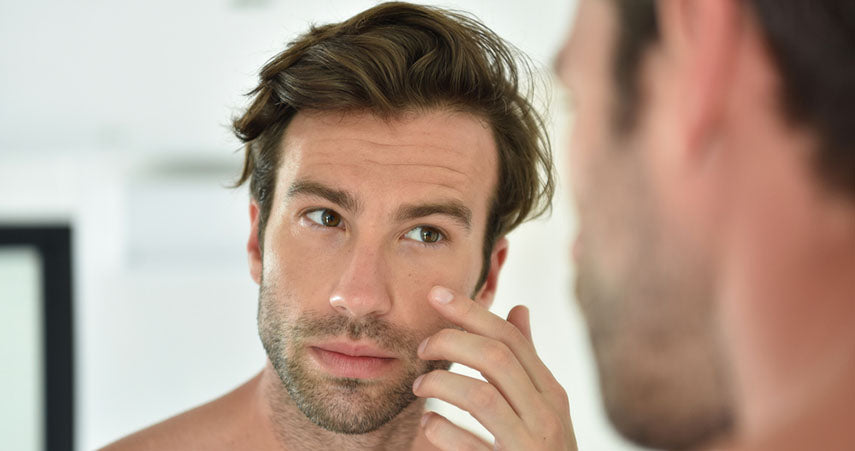 man using cream on face