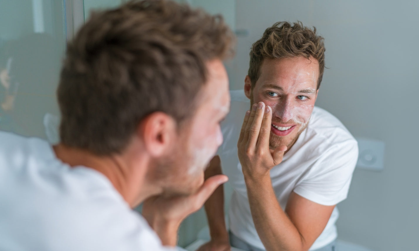 Man washing his face with a foaming exfoliating scrub