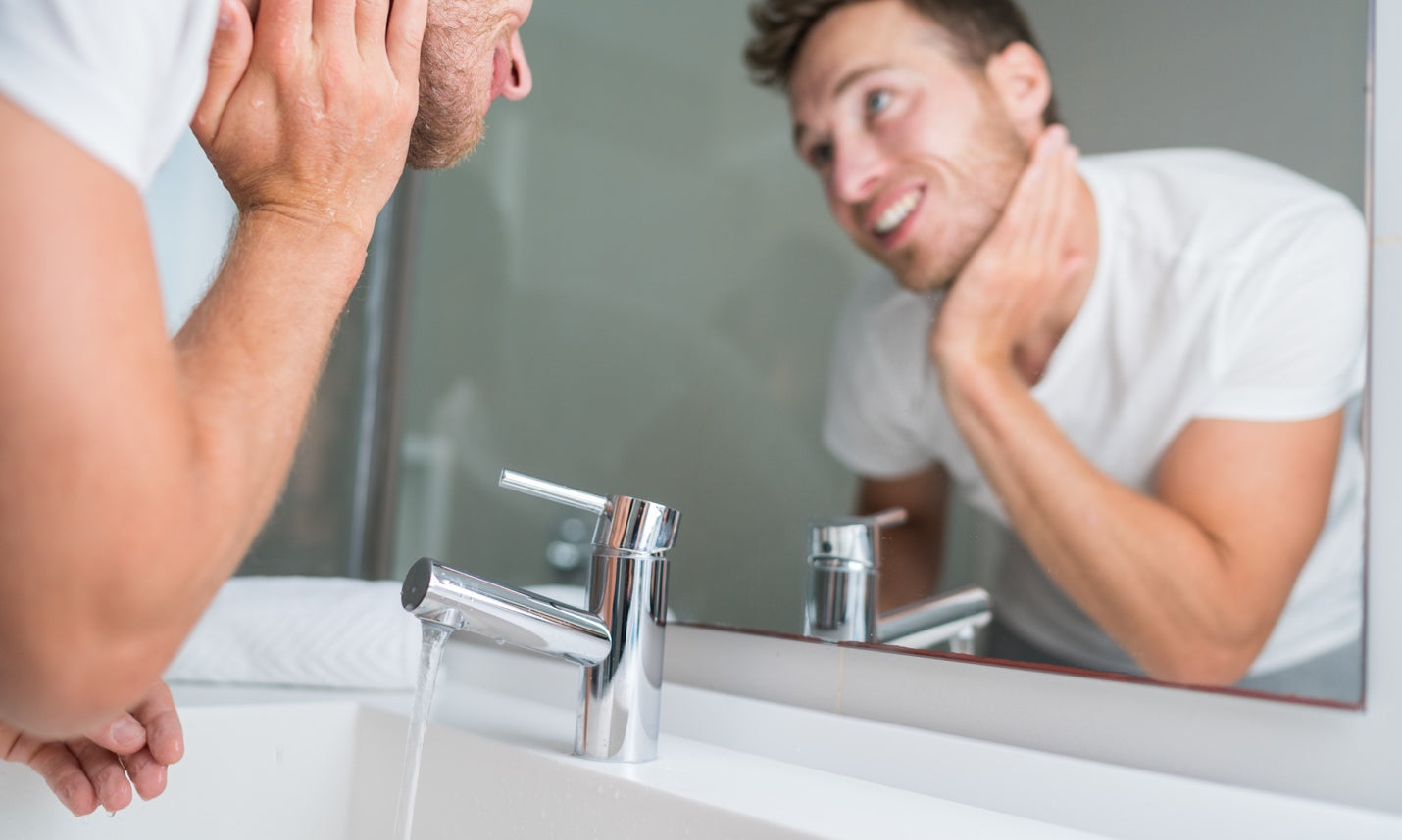 Man using moisturizer over the bathroom sink