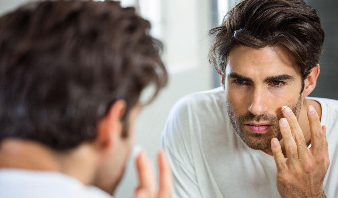 reflection of man inspecting face