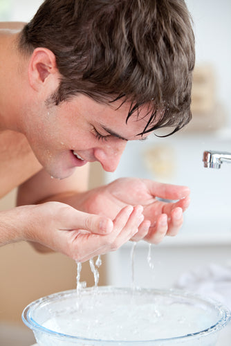 man splashing water on face