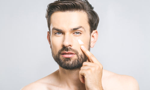 man applying eye cream