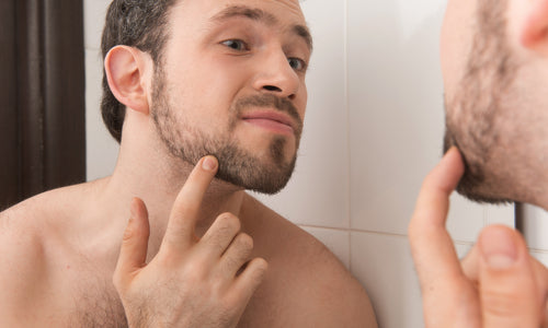 young man examining his stubble